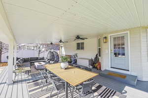 Wooden deck featuring an outdoor living space and ceiling fan