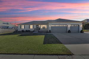 View of front of home with a garage and a yard