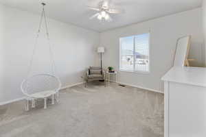 Living area featuring light carpet and ceiling fan