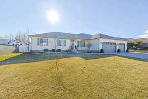 Ranch-style home with a front lawn and a garage