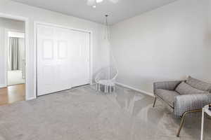 Living area with light colored carpet and ceiling fan