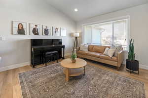 Living room with plenty of natural light, hardwood / wood-style floors, and vaulted ceiling