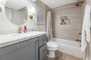 Full bathroom featuring vanity, toilet, and shower / bath combo with shower curtain