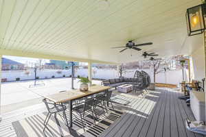 Snow covered deck with an outdoor living space and ceiling fan