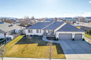 Ranch-style house featuring a front lawn and a garage