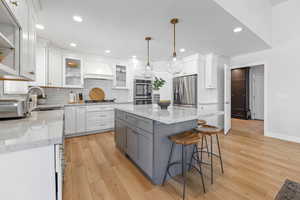 Kitchen featuring a center island, sink, white cabinetry, and stainless steel appliances