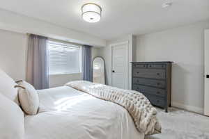 Bedroom featuring light carpet