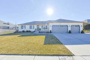 Ranch-style house featuring a front yard and a garage