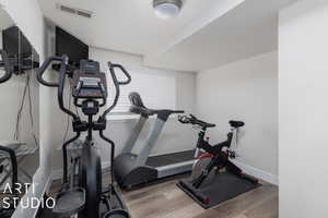 Exercise area with dark hardwood / wood-style floors and a textured ceiling