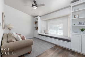 Sitting room featuring ceiling fan, dark wood-type flooring, and a textured ceiling