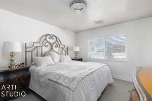 Carpeted bedroom featuring a textured ceiling