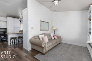 Living room with ceiling fan and dark hardwood / wood-style flooring