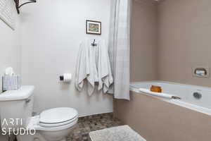 Bathroom with tile patterned floors, toilet, and a bathtub