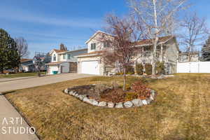 View of front of property featuring a front lawn, covered porch, and a garage