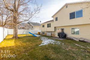 Rear view of property featuring a playground and a yard