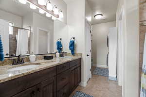 Bathroom featuring a shower with curtain and vanity