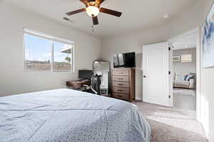 Carpeted bedroom featuring ceiling fan