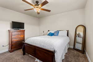 Carpeted bedroom with ceiling fan