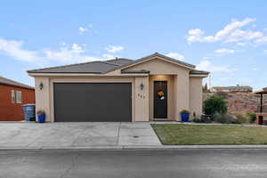 View of front of property featuring a front lawn and a garage