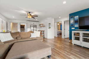 Living room with light wood-type flooring and ceiling fan