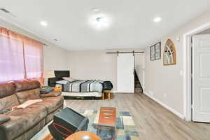 Living room featuring light wood-type flooring and a barn door