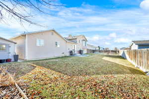 Rear view of property featuring central AC, a patio area, and a yard