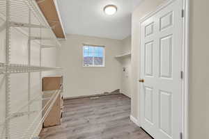 Washroom with a textured ceiling and light hardwood / wood-style flooring