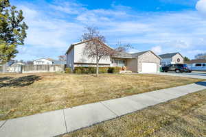 View of front facade featuring a garage and a front lawn