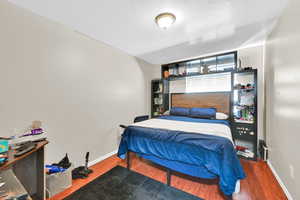 Bedroom with a textured ceiling and hardwood / wood-style flooring