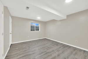 Basement with light hardwood / wood-style flooring