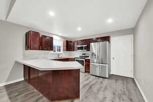 Kitchen featuring light hardwood / wood-style floors, sink, stainless steel appliances, and kitchen peninsula