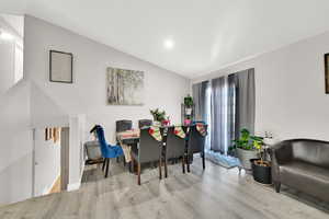 Dining space featuring light wood-type flooring and lofted ceiling