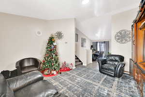 Living room featuring dark hardwood / wood-style flooring and vaulted ceiling