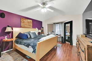 Bedroom featuring wood-type flooring, ceiling fan, and lofted ceiling