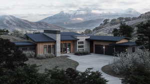 View of front of home featuring a mountain view and a garage