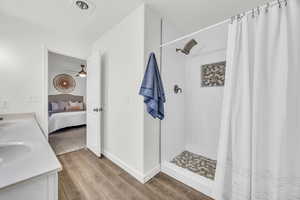 Bathroom with a shower with shower curtain, vanity