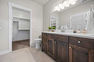 Bathroom featuring tile patterned flooring, vanity, and toilet