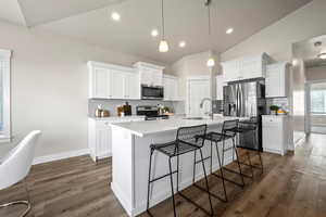 Kitchen with white cabinets, sink, stainless steel appliances, and a kitchen island with sink