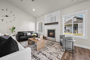 Living room featuring plenty of natural light, hardwood / wood-style floors, and lofted ceiling