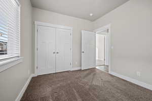 Unfurnished bedroom featuring carpet flooring and a closet