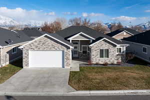 View of front of house with a mountain view, a front yard, and a garage