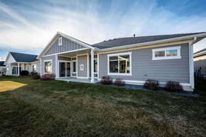 Rear view of property featuring a yard and a patio