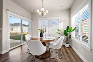 Dining area featuring plenty of natural light, dark hardwood / wood-style floors, and an inviting chandelier