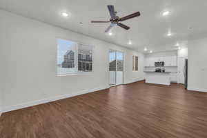 Unfurnished living room featuring dark hardwood / wood-style floors and ceiling fan