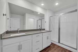 Bathroom with vanity, wood-type flooring, and a shower with shower door