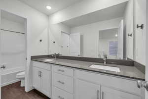 Full bathroom featuring shower / bath combination, vanity, a textured ceiling, hardwood / wood-style flooring, and toilet