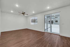 Spare room featuring ceiling fan and dark wood-type flooring