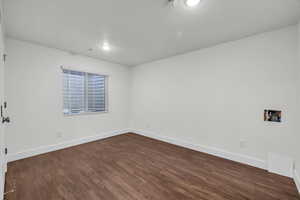 Spare room featuring dark hardwood / wood-style flooring and a textured ceiling