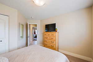 Bedroom with light carpet and a closet