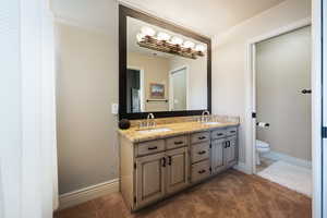 Bathroom with a textured ceiling, vanity, and toilet